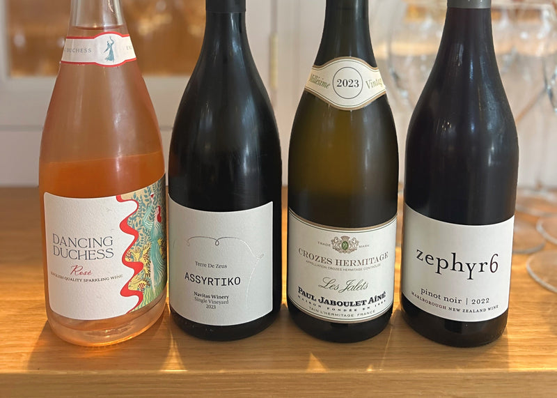 Four wine bottles on a bar counter with a blurred bar background